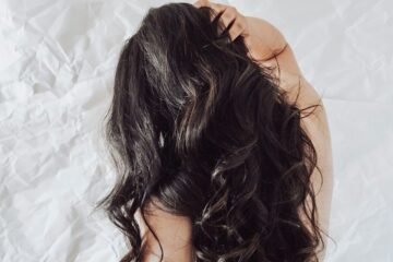 Donna che accarezza i suoi capelli lunghi e sani