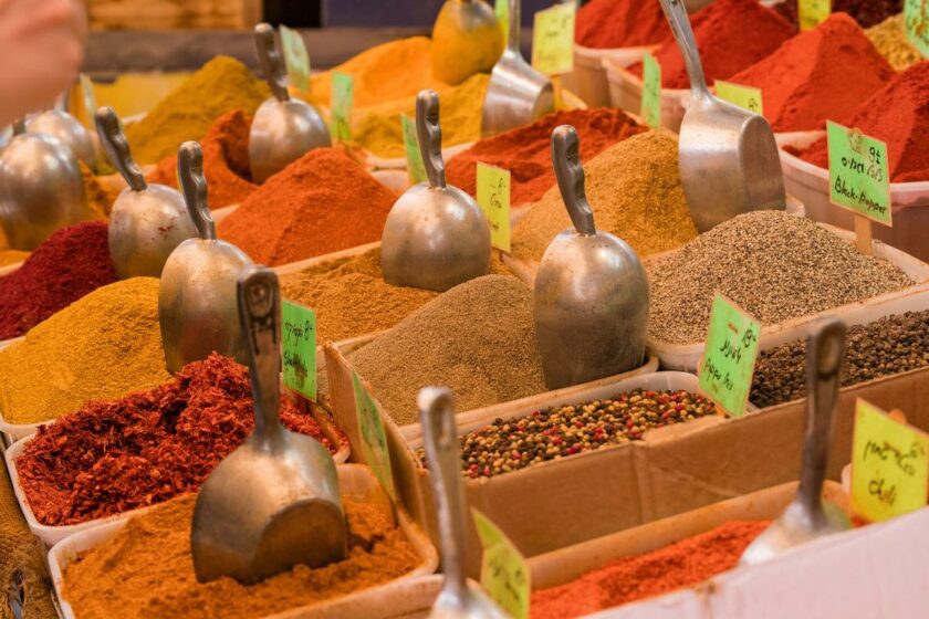 Assortimento di spezie indiane colorate in piccole ciotole su un tavolo in legno