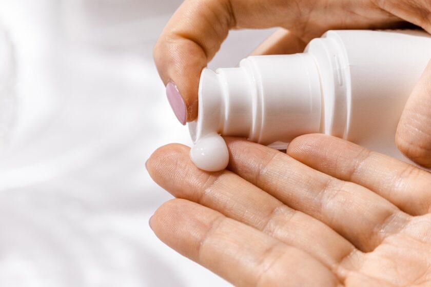 Donna che si appresta a massaggiarsi le gambe con crema anticellulite