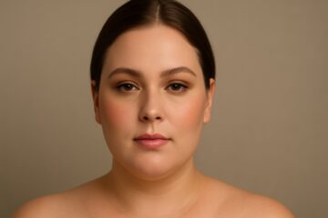 Donna con viso tondo truccata con make up correttivo, contouring leggero e blush in alto sugli zigomi.
