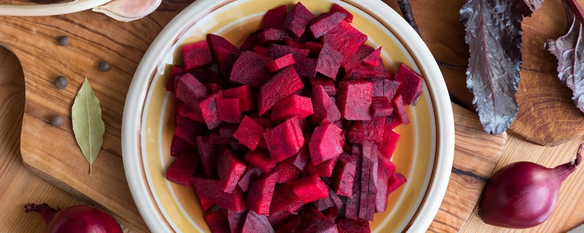 Barbabietola rossa fresca tagliata su tagliere in cucina