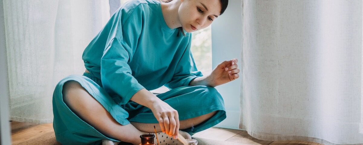 Donna in ambiente domestico con candele in atmosfera spirituale