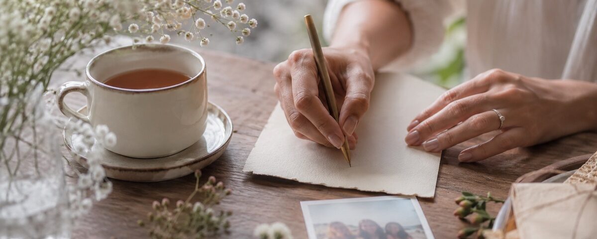 Mani che scrivono una dedica su un biglietto per un'amica speciale.