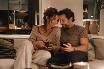 Coppia adulta sul divano mentre ascolta una canzone romantica insieme
