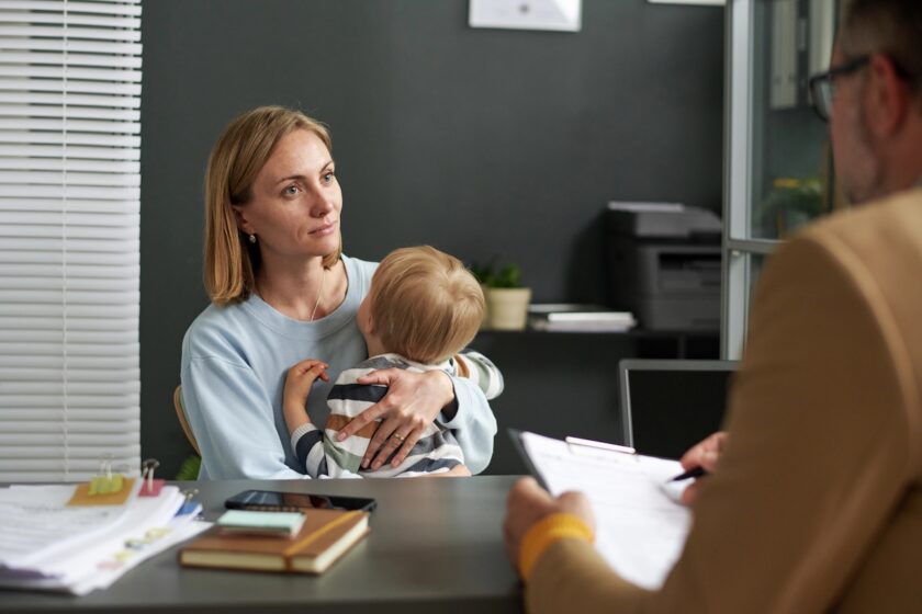 Madre con figlia durante un colloquio con una consulente che mostra alcuni documenti