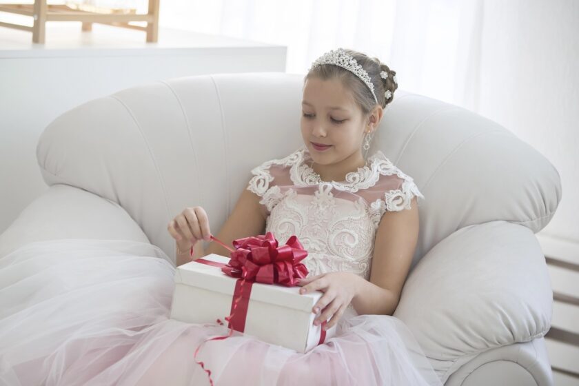 Un bambino apre un regalo durante il pranzo per la prima comunione